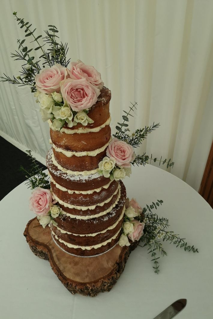 pink and white naked wedding cake by Cakes Sussex